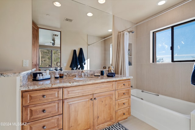 bathroom featuring tile patterned floors, ceiling fan, shower / bath combo with shower curtain, and vanity