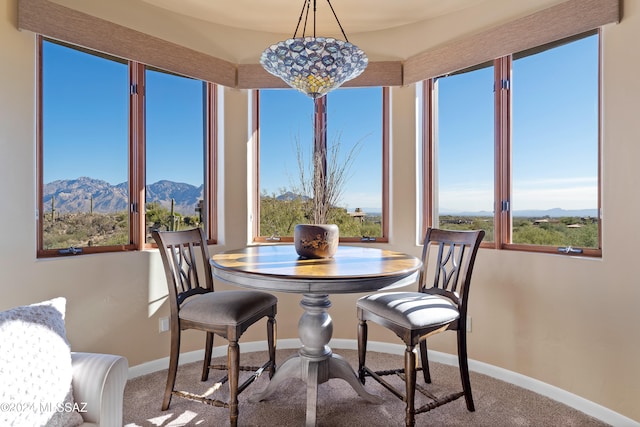 dining space with a mountain view and carpet floors