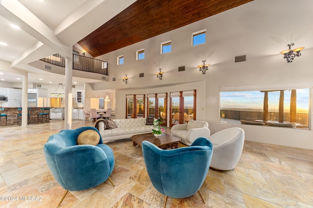 living room featuring beam ceiling and high vaulted ceiling