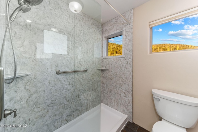 bathroom featuring a tile shower, tile patterned flooring, and toilet