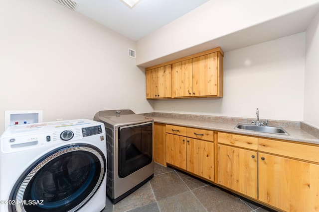 clothes washing area featuring cabinets, independent washer and dryer, and sink