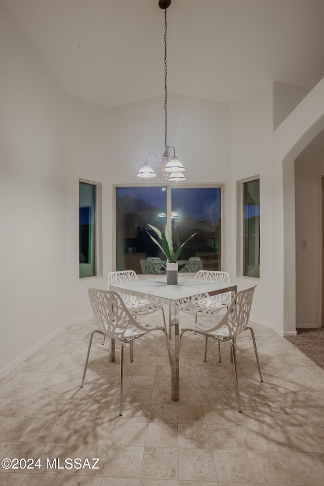 dining room with high vaulted ceiling and an inviting chandelier