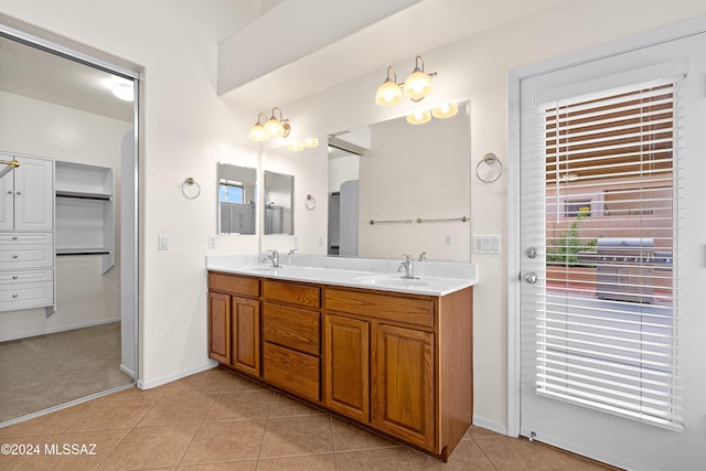 full bathroom featuring tile patterned flooring, double vanity, plenty of natural light, and a sink