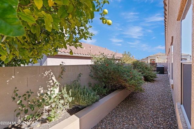 view of side of home with a tile roof and a fenced backyard