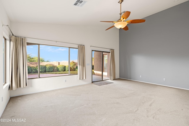 spare room with visible vents, baseboards, carpet, high vaulted ceiling, and a ceiling fan