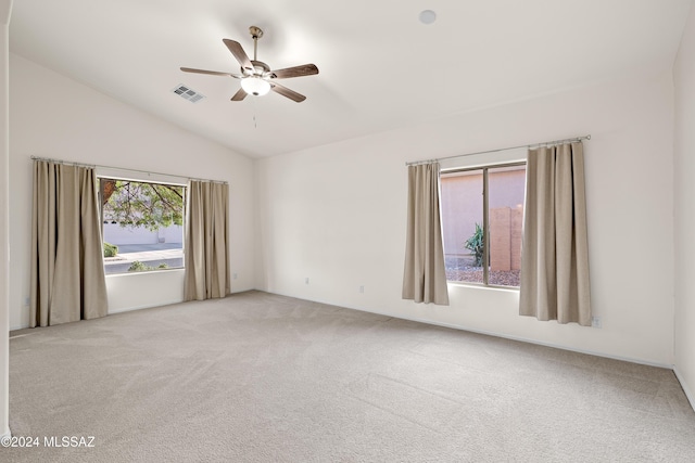 carpeted empty room with visible vents, lofted ceiling, and ceiling fan