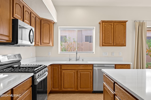 kitchen with a sink, appliances with stainless steel finishes, and brown cabinetry