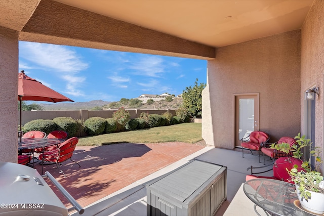 view of patio / terrace featuring outdoor dining space, a mountain view, grilling area, and fence