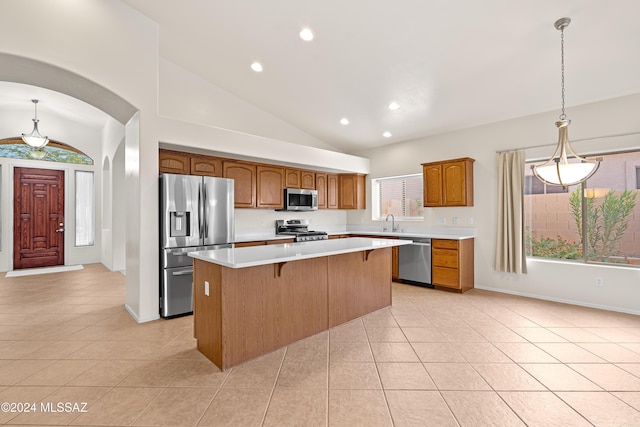 kitchen with light countertops, light tile patterned flooring, appliances with stainless steel finishes, and a center island