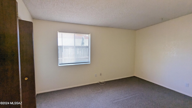 carpeted empty room with a textured ceiling