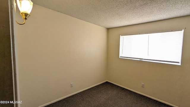 carpeted spare room featuring a textured ceiling