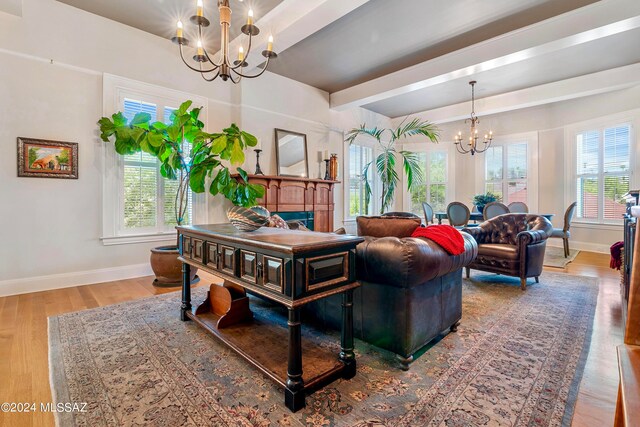 living room with beamed ceiling, hardwood / wood-style floors, and an inviting chandelier