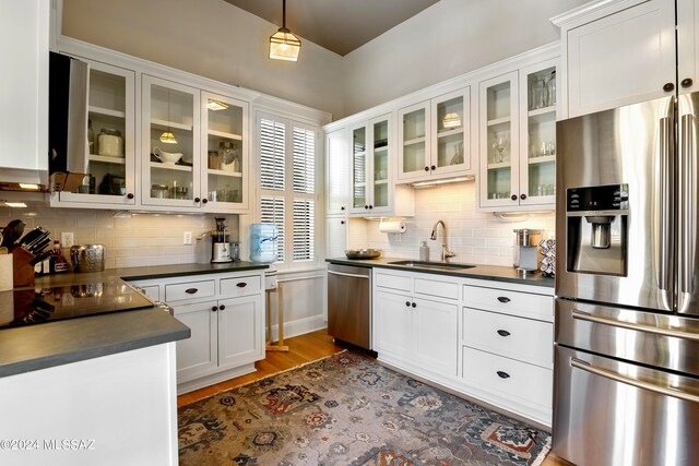 kitchen featuring white cabinets, sink, tasteful backsplash, dark hardwood / wood-style flooring, and stainless steel appliances