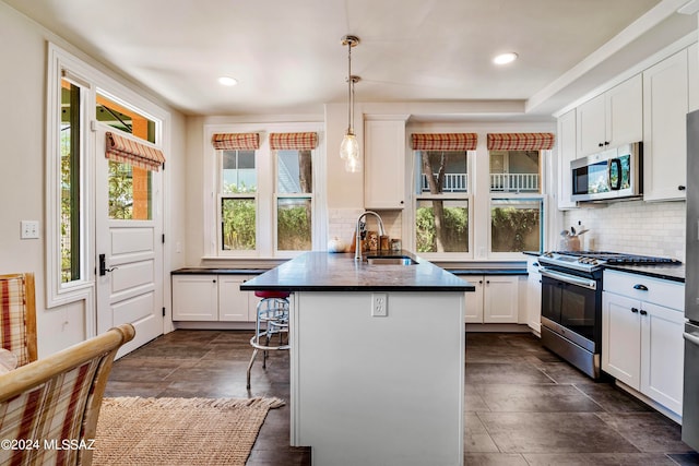 kitchen featuring white cabinets, a healthy amount of sunlight, sink, and appliances with stainless steel finishes