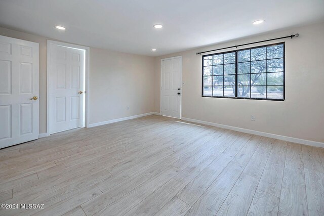 unfurnished bedroom with light hardwood / wood-style floors, a closet, and a wall mounted AC