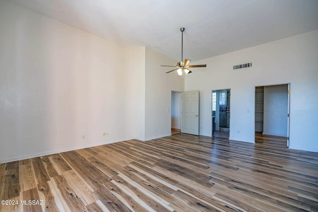 spare room with dark wood-type flooring, ceiling fan, and high vaulted ceiling