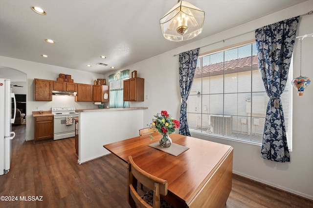 dining space featuring dark hardwood / wood-style flooring and an inviting chandelier