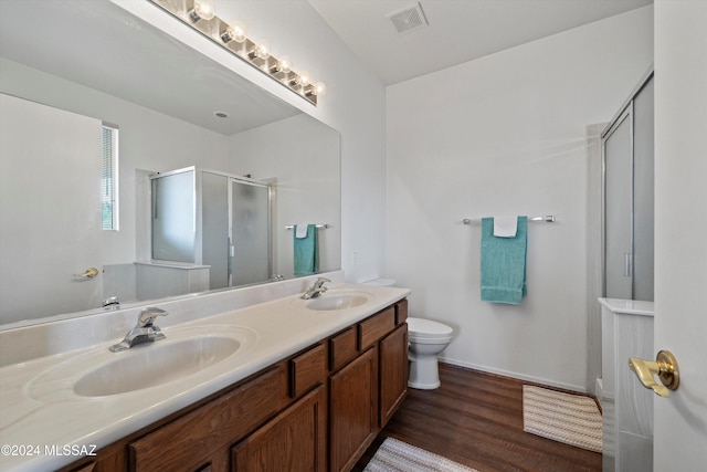 bathroom featuring hardwood / wood-style floors, vanity, toilet, and a shower with shower door