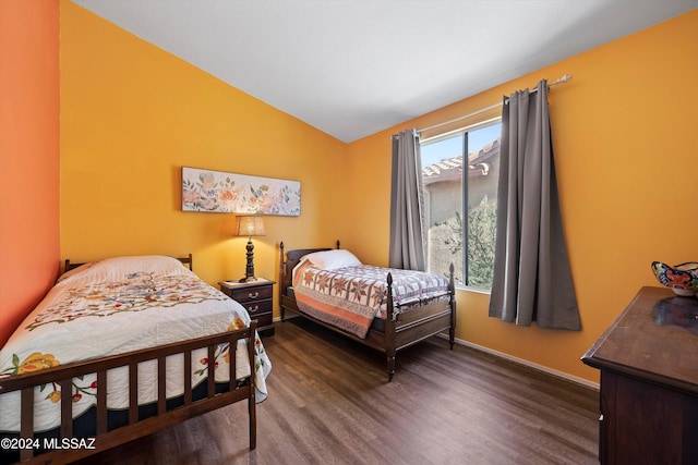 bedroom with dark hardwood / wood-style flooring and lofted ceiling