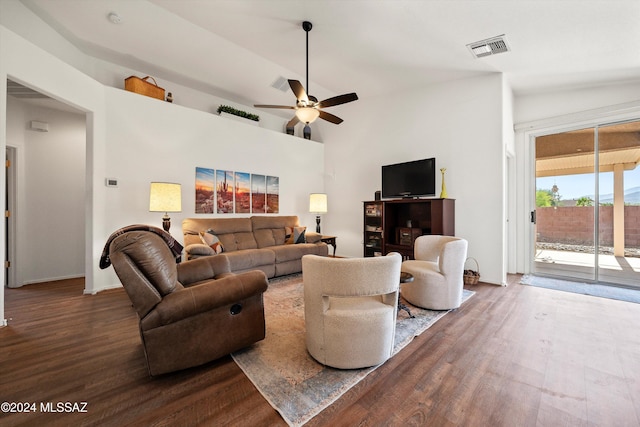 living room featuring vaulted ceiling, ceiling fan, and dark wood-type flooring