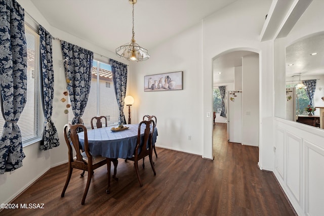 dining space with dark hardwood / wood-style flooring and a chandelier