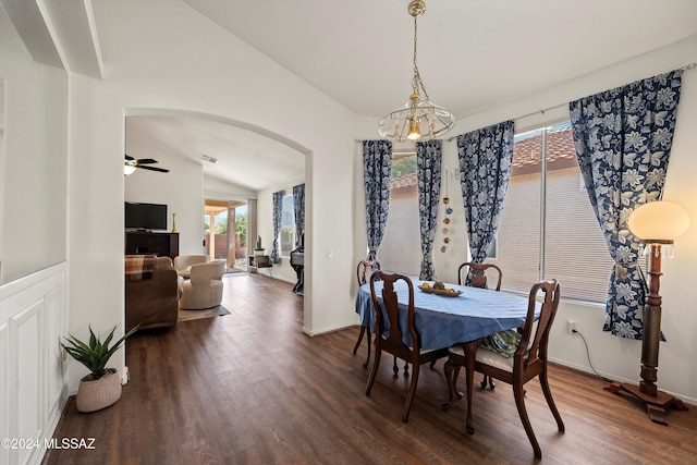 dining space featuring ceiling fan with notable chandelier, dark wood-type flooring, and lofted ceiling