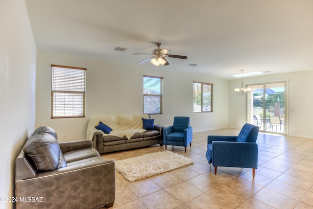 living room featuring light tile patterned floors and ceiling fan with notable chandelier