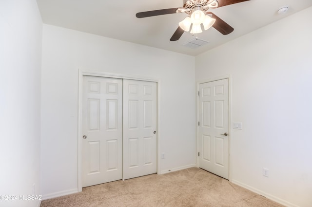 unfurnished bedroom with ceiling fan, a closet, and light carpet