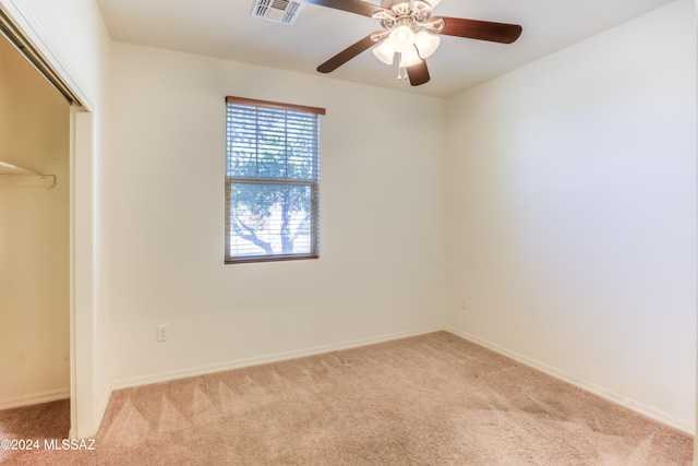 unfurnished bedroom featuring ceiling fan, light carpet, and a closet