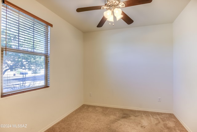 carpeted spare room with ceiling fan