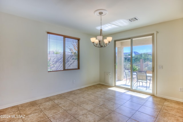 tiled spare room with a notable chandelier and plenty of natural light