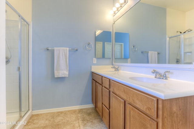 bathroom with tile patterned flooring, vanity, and an enclosed shower