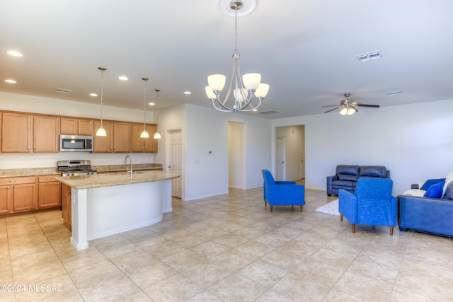 kitchen featuring a center island with sink, ceiling fan with notable chandelier, sink, hanging light fixtures, and appliances with stainless steel finishes