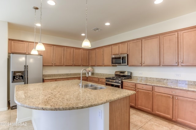 kitchen with a center island with sink, sink, hanging light fixtures, light tile patterned flooring, and stainless steel appliances