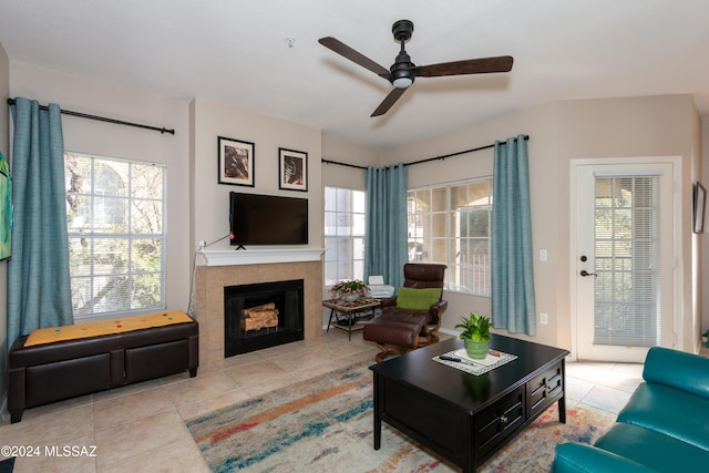 tiled living room featuring a tile fireplace and ceiling fan