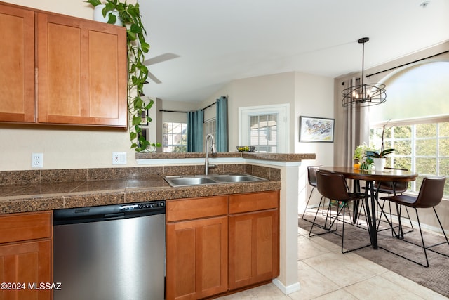 kitchen featuring light tile patterned floors, sink, pendant lighting, stainless steel dishwasher, and kitchen peninsula