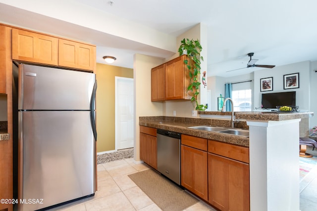 kitchen with light tile patterned floors, sink, ceiling fan, stainless steel appliances, and kitchen peninsula