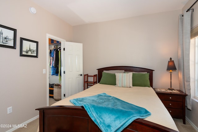 bedroom featuring light carpet, a closet, and a walk in closet