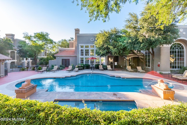 view of pool featuring pool water feature and a patio