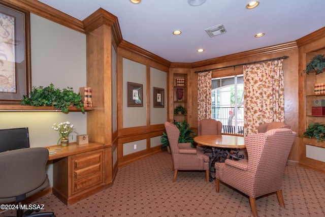 carpeted home office featuring ornamental molding and built in desk