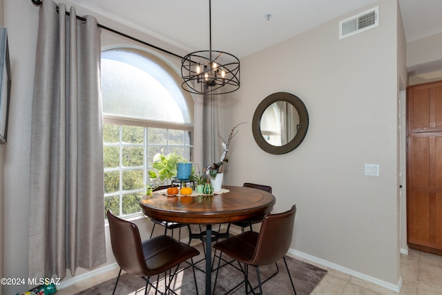 tiled dining area with an inviting chandelier