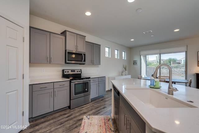 kitchen featuring gray cabinets, a sink, appliances with stainless steel finishes, and recessed lighting