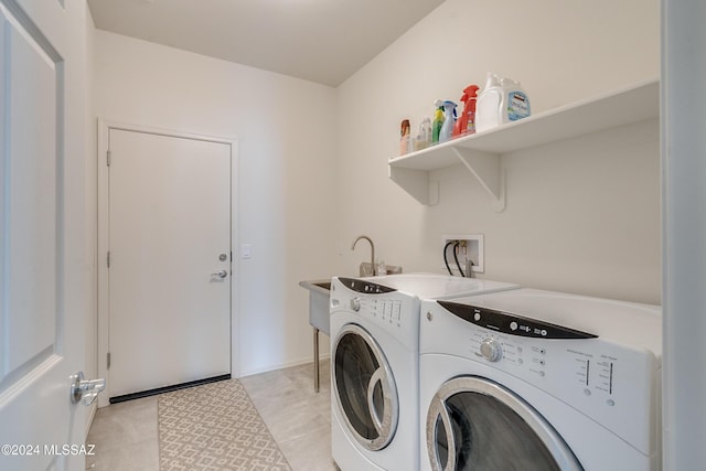 washroom with washing machine and dryer, laundry area, and a sink