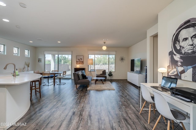 living area with dark wood-type flooring and recessed lighting