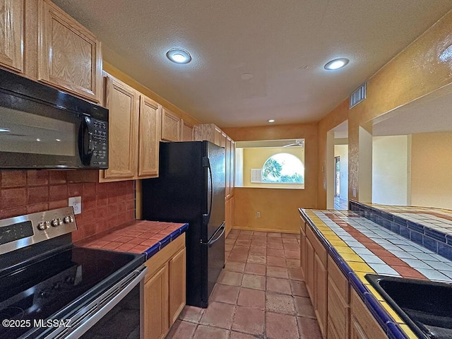 8034 E Shadow Ln, Tucson, AZ 85750 - kitchen with tile counters, black appliances, tasteful backsplash, recessed lighting, and a sink