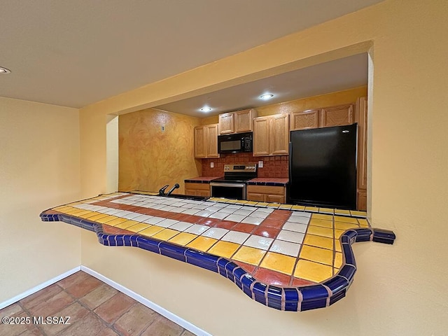 8034 E Shadow Ln, Tucson, AZ 85750 - kitchen with black appliances, tile countertops, a peninsula, backsplash, and baseboards