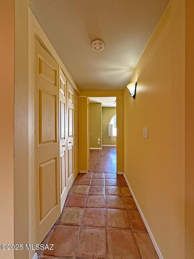 8034 E Shadow Ln, Tucson, AZ 85750 - corridor featuring baseboards and a textured ceiling