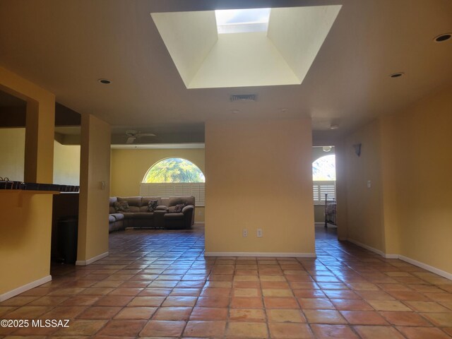 tiled empty room featuring ceiling fan