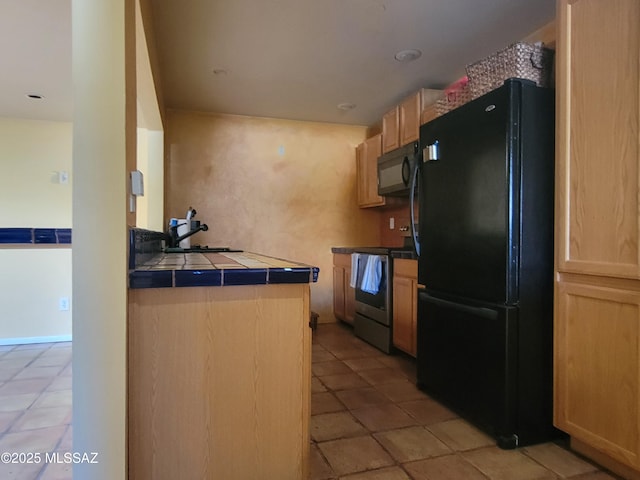 kitchen featuring sink, tile countertops, black appliances, and light brown cabinets