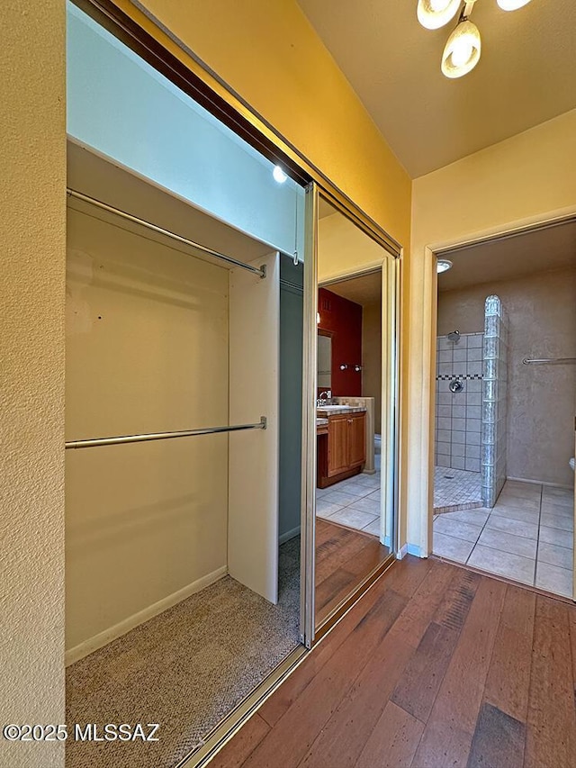 8034 E Shadow Ln, Tucson, AZ 85750 - bathroom featuring a tile shower and hardwood / wood-style flooring